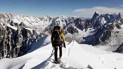 An alpinist heads down a ridge on the Aiguille du Midi (3.842 m), towards the Vallee Blanche on the Mont Blanc massif, in the Alps, near Chamonix, France,