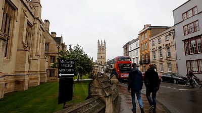 In this Sunday, Sept. 3, 2017 photo, people walk around Oxford University's campus in Oxford, England.