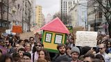 Protestors carry a mock house during a demonstration to demand solutions for Portugal's housing crisis, in Lisbon, Portugal, in April 2023.
