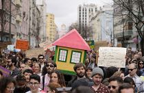 Protestors carry a mock house during a demonstration to demand solutions for Portugal's housing crisis, in Lisbon, Portugal, in April 2023.