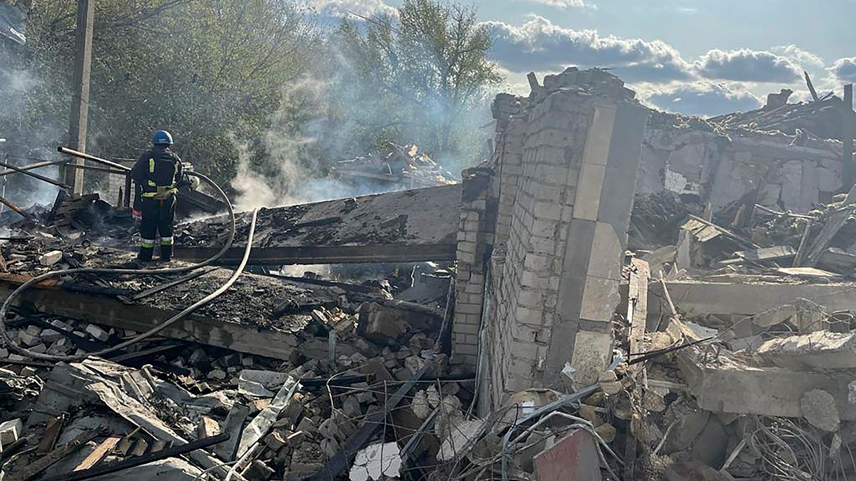 Bombeiros tentam apagar o fogo no local do bombardeamento em Hroza, na Ucrânia