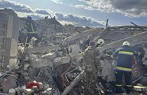 Emergency workers search the victims of a Russian rocket attack that killed at least 47 people in the village of Hroza near Kharkiv, Ukraine, Thursday, Oct. 5, 2023. 