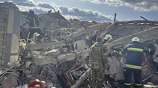 Emergency workers search the victims of a Russian rocket attack that killed at least 47 people in the village of Hroza near Kharkiv, Ukraine, Thursday, Oct. 5, 2023. 