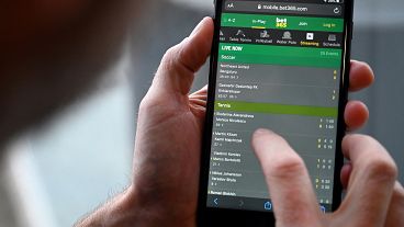 A man browses online gambling website Bet365 on a smartphone.