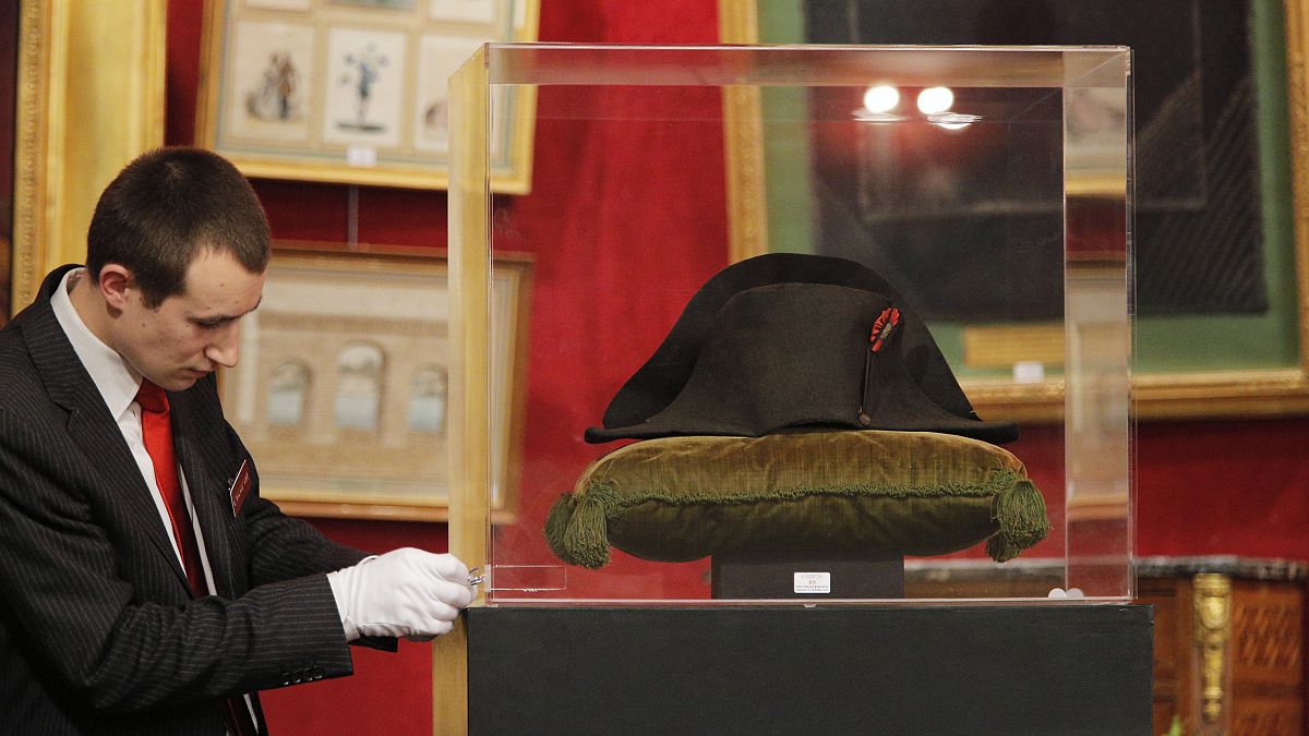 موظف يقوم بإعداد قبعة نابليون قبل بيعها بالمزاد العلني في فونتينبلو