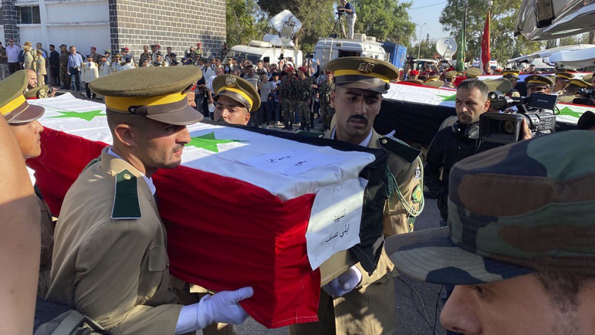 Syrian student officers carry the coffins of a victim who were killed on Thursday in a drone attack that hit a military graduation ceremony, during a mass funeral procession.