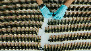 FILE - A police officer organises seized bullet cartridges as they are displayed to the press at the regional police headquarters in Cali, southern Colombia, 2010.