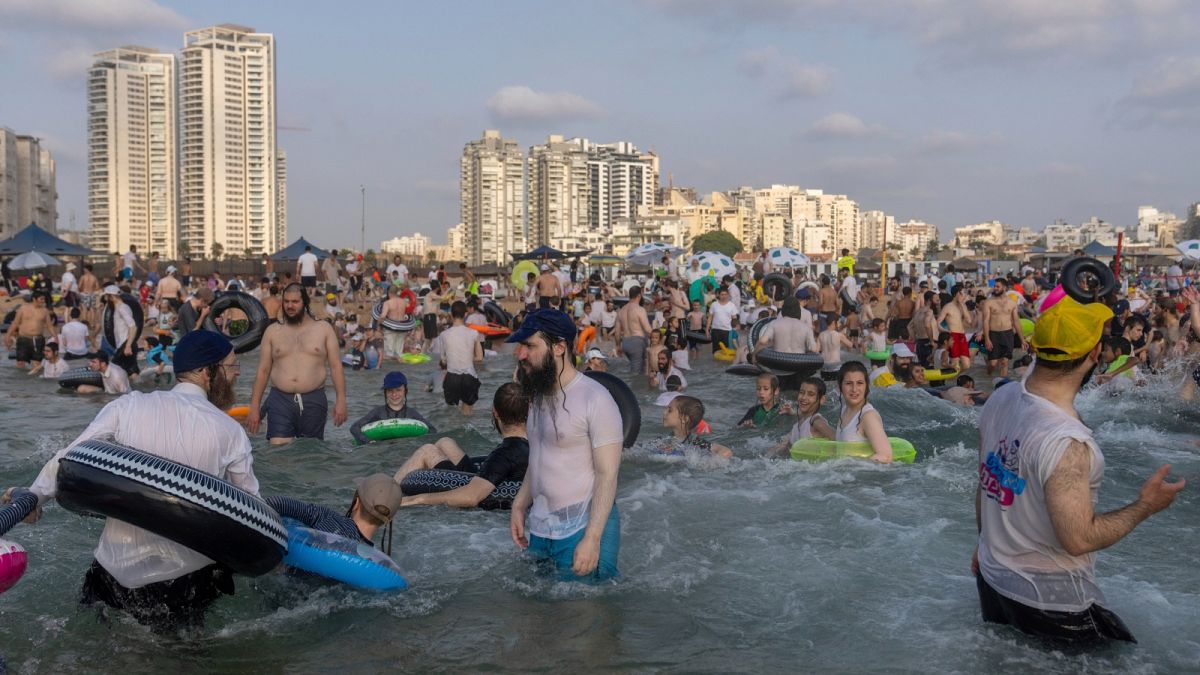 يقضي الرجال والأطفال اليهود المتدينون يومهم على شاطئ منفصل في أشدود، إسرائيل، الأربعاء، 16 أغسطس، 2023. الشاطئ منفصل بحيث يكون الرجال والنساء فقط في الأيام المتناوبة.