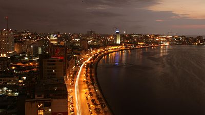 The city lights of the Angolan capital, Luanda, light up the sky.