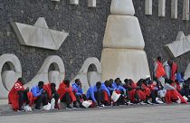 مهاجرون يجلسون متجمعين في بطانيات على الرصيف في لا ريستينجا بجزيرة إل هييرو الكناري بإسبانيا يوم الأربعاء 4 أكتوبر 2023.