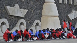 مهاجرون يجلسون متجمعين في بطانيات على الرصيف في لا ريستينجا بجزيرة إل هييرو الكناري بإسبانيا يوم الأربعاء 4 أكتوبر 2023.