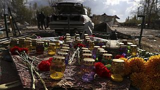 A memorial made with candles and flowers, which were brought by local residents, in the village of Hroza near Kharkiv, Ukraine, Friday, Oct. 6, 2023. 