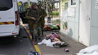Soldados israelíes pasan junto a víctimas de los ataques de Hamás en Sderot