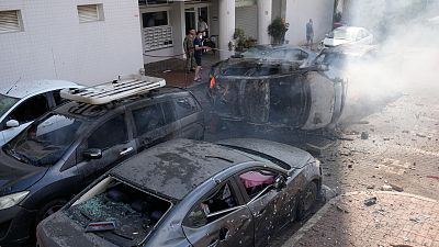 Cars are on fire after they were hit by rockets from the Gaza Strip in Ashkelon, Israel