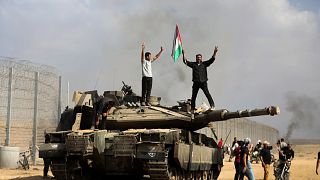 Palestinianos festejam em cima de um tanque israelita