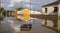 Uma mala flutua numa rua inundada na aldeia de Sotirio, na Grécia
