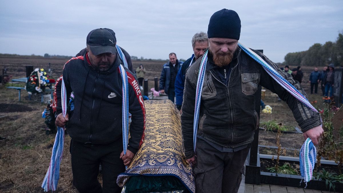Civiles cargando con un ataúd en el funeral del pueblo de Groza, tras los bombardeos rusos.