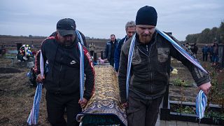 Civiles cargando con un ataúd en el funeral del pueblo de Groza, tras los bombardeos rusos.
