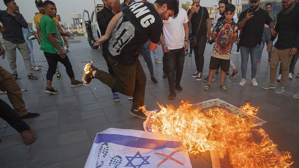 Iracheni bruciano bandiere israeliane durante una manifestazione tenutasi sabato nel centro di Baghdad a sostegno dei palestinesi