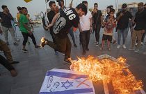 Iraker verbrennen israelische Flaggen während einer Kundgebung im Zentrum Bagdads zur Unterstützung der Palästinenser am Samstag