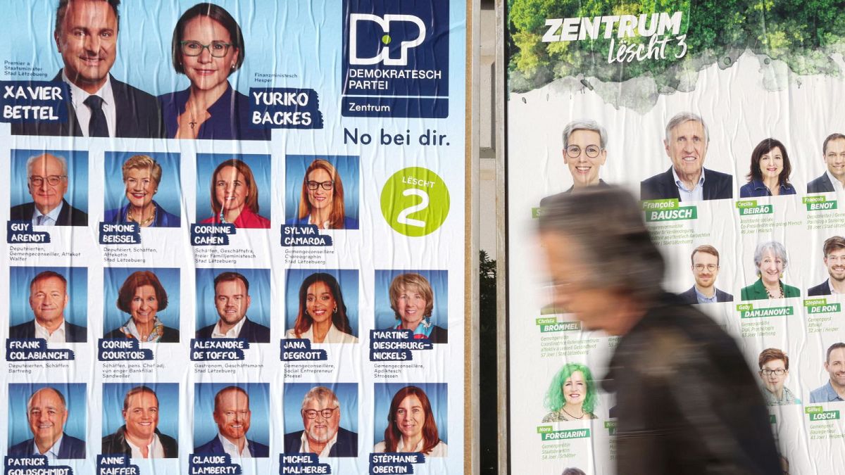 A man passes in front of an election poster for the Luxembourg's legislative elections in Luxembourg, on October 8, 2023.