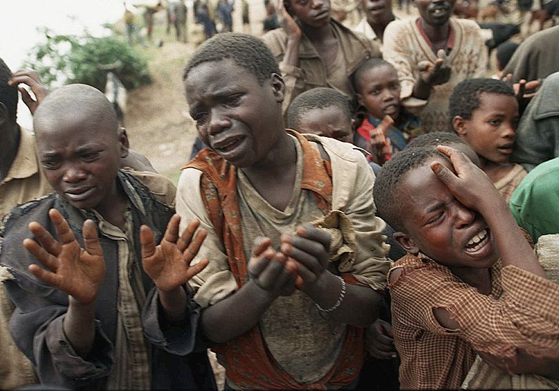 Des enfants réfugiés rwandais implorent les soldats zaïrois de leur permettre de traverser le pont qui sépare le Rwanda du Zaïre de l'époque, en 1994.