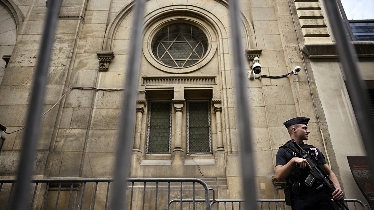 A French riot policeman (CRS) stands guard outside the Paris Synagogue. 