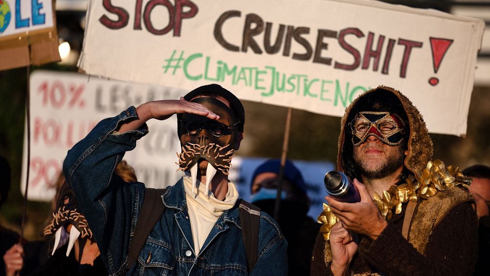Членове на антикруизния колектив anti croisieres носещи маски участват в демонстрацията