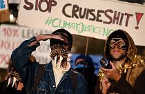 Members of the anti-cruise collective (anti-croisieres) wearing masks take part in the demonstration in the port du Rosmeur in Douarnenez.