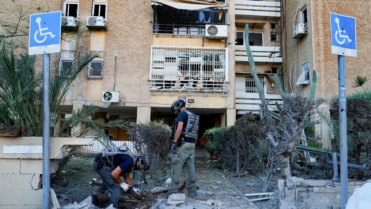 Members of Israeli bomb squad unit inspect a site hit by a rocket fired from the Gaza Strip, in Ashkelon, Israel, Tuesday, Oct. 10, 2023. 
