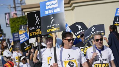 While writers have signed their new deal with studios, union leaders say they'll continue to picket with striking actors.