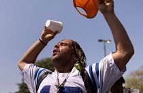 A man pours water atop his head outside the Emergency Aid Coalition during a heat wave in Houston, Texas, US, August 2023. 