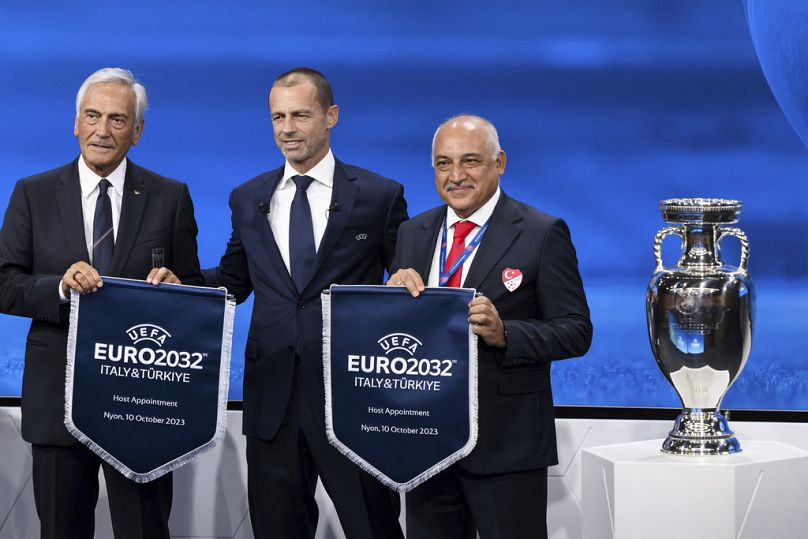 UEFA president Aleksander Ceferin, center, shows the name of Italy and Turkey elected to host the Euro 2032 fooball tournament