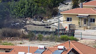 دبابة إسرائيلية بين المنازل في بلدة المطلة الإسرائيلية كما يُرى من الجانب اللبناني من الحدود اللبنانية -الإسرائيلية في قرية كفر كلا الجنوبية، لبنان، 9 أكتوبر 2023