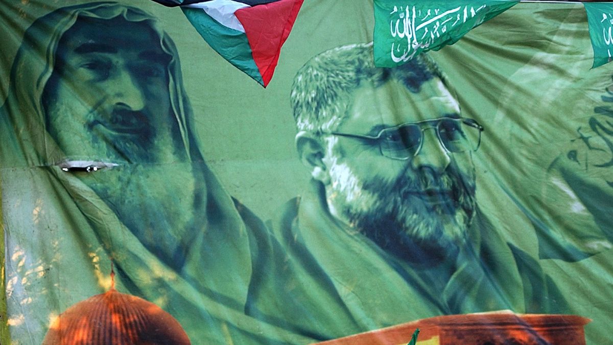 FILE: Palestinian Hamas supporters stand under a banner showing late leader Sheik Ahmed Yassin, left, and Abdel Aziz Rantisi. March 2007, Nablus