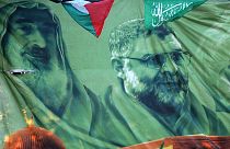 DOSYA: Filistinli Hamas destekçileri, solda merhum lider Şeyh Ahmed Yasin ve Abdülaziz Rantisi'yi gösteren bir pankartın altında duruyor. Mart 2007, Nablus