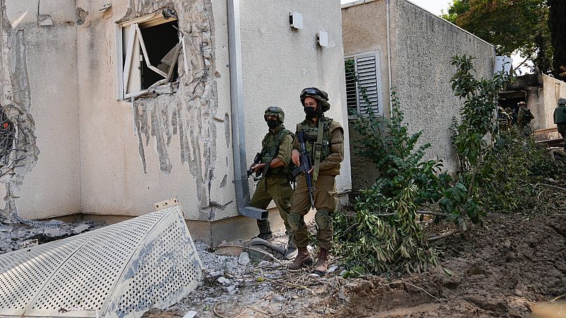 Israeli soldiers stand guard in kibbutz Kfar Azza on Tuesday.