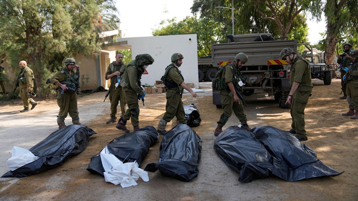 نیروهای ارتش اسرائیل در کنار کشته‌شدگان به تاریخ دهم اکتبر ۲۰۲۳