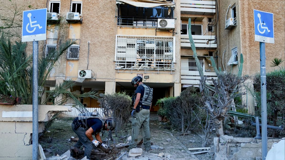 أعضاء وحدة القنابل الإسرائيلية يتفقدون موقعًا أصيب بصاروخ أطلق من قطاع غزة في عسقلان.
