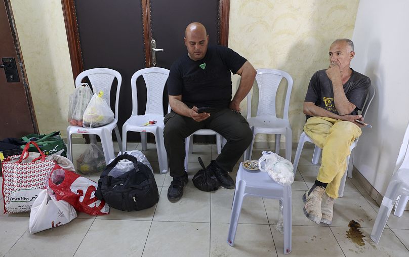عاملان فلسطينيان من غزة يجلسان في غرفة فندق برام الله بالضفة الغربية المحتلة
