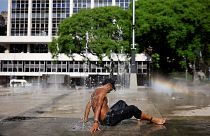 A man uses a fountain to cool off during a heatwave in the Anhangabau Valley, in the centre of Sao Paulo, Brazil, September 2023.