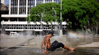 A man uses a fountain to cool off during a heatwave in the Anhangabau Valley, in the centre of Sao Paulo, Brazil, September 2023.