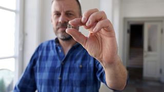  Старшият откривател в Националния музей на Дания Мадс Денгсьо Йесен държи откъс от стъкло на прозорец от епохата на викингите. 