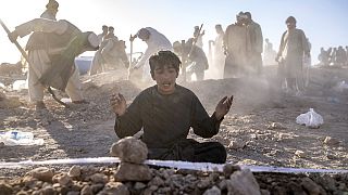 صبي أفغاني ينعي بجوار قبر أخيه الصغير الذي توفي بسبب زلزال، في منطقة زندا جان في مقاطعة هرات، غرب أفغانستان، الاثنين 9 أكتوبر 2023