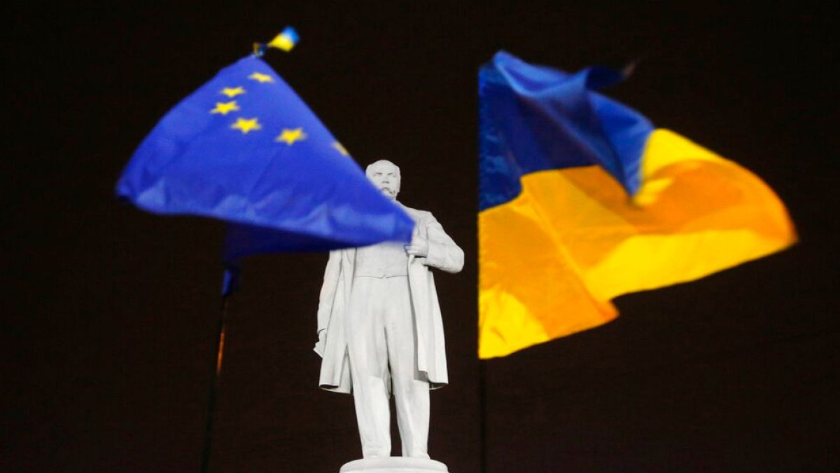 FILE - Foto del 5 dicembre 2013: manifestanti dell'opposizione tengono le bandiere dell'UE e dell'Ucraina, a destra, intorno al monumento al poeta ucraino Taras Shevchenko nel centro di Donetsk.