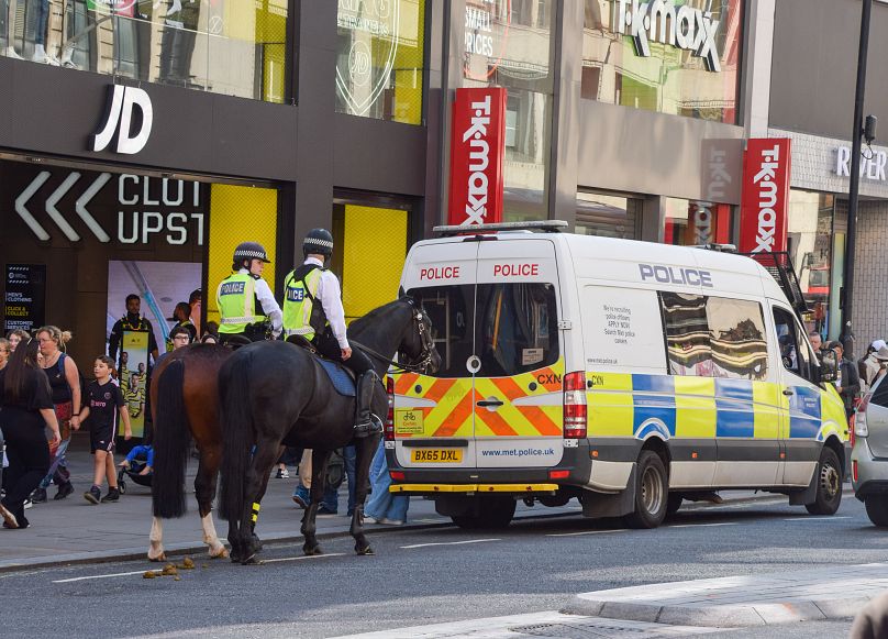 Police officers guard JD Sports on Oxford Street in August - the target of a mass shoplifting event