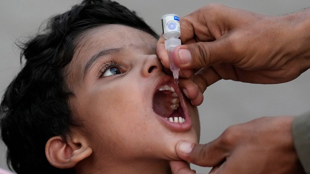 Здравен работник прилага полиомиелитна ваксина на дете на жп гара