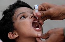 A health worker administers a polio vaccine to a child at a railway station in Karachi, Pakistan, September 2023