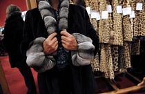 A woman tries on a fur coat, on October 25, 2008 at Hotel Drouot in Paris, two days before fashion items are to be auctioned.