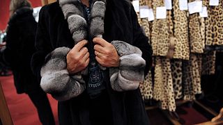 Une femme essaie un manteau de fourrure, le 25 octobre 2008 à l'hôtel Drouot à Paris, deux jours avant la vente aux enchères d'articles de mode.